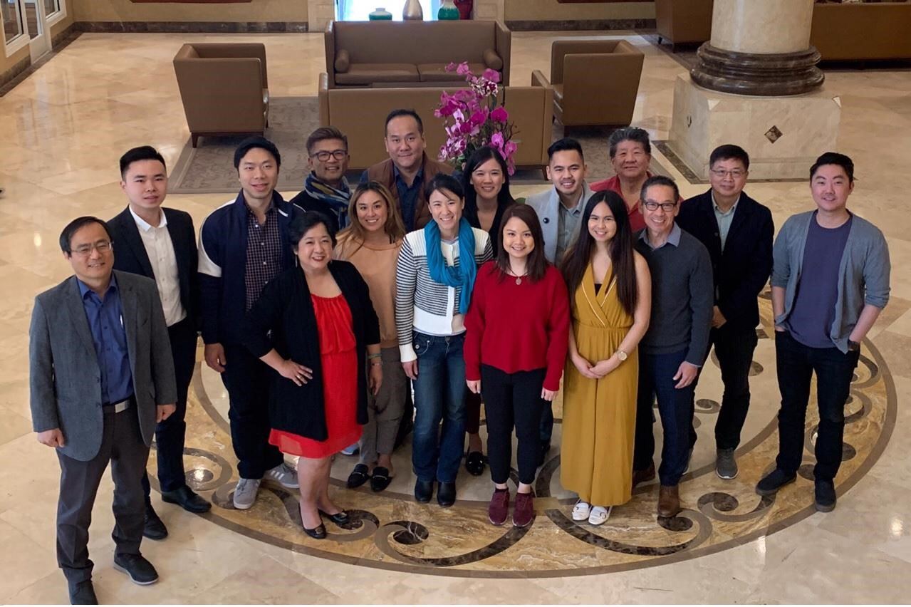 A group picture of Asian American professionals in a hotel lobby